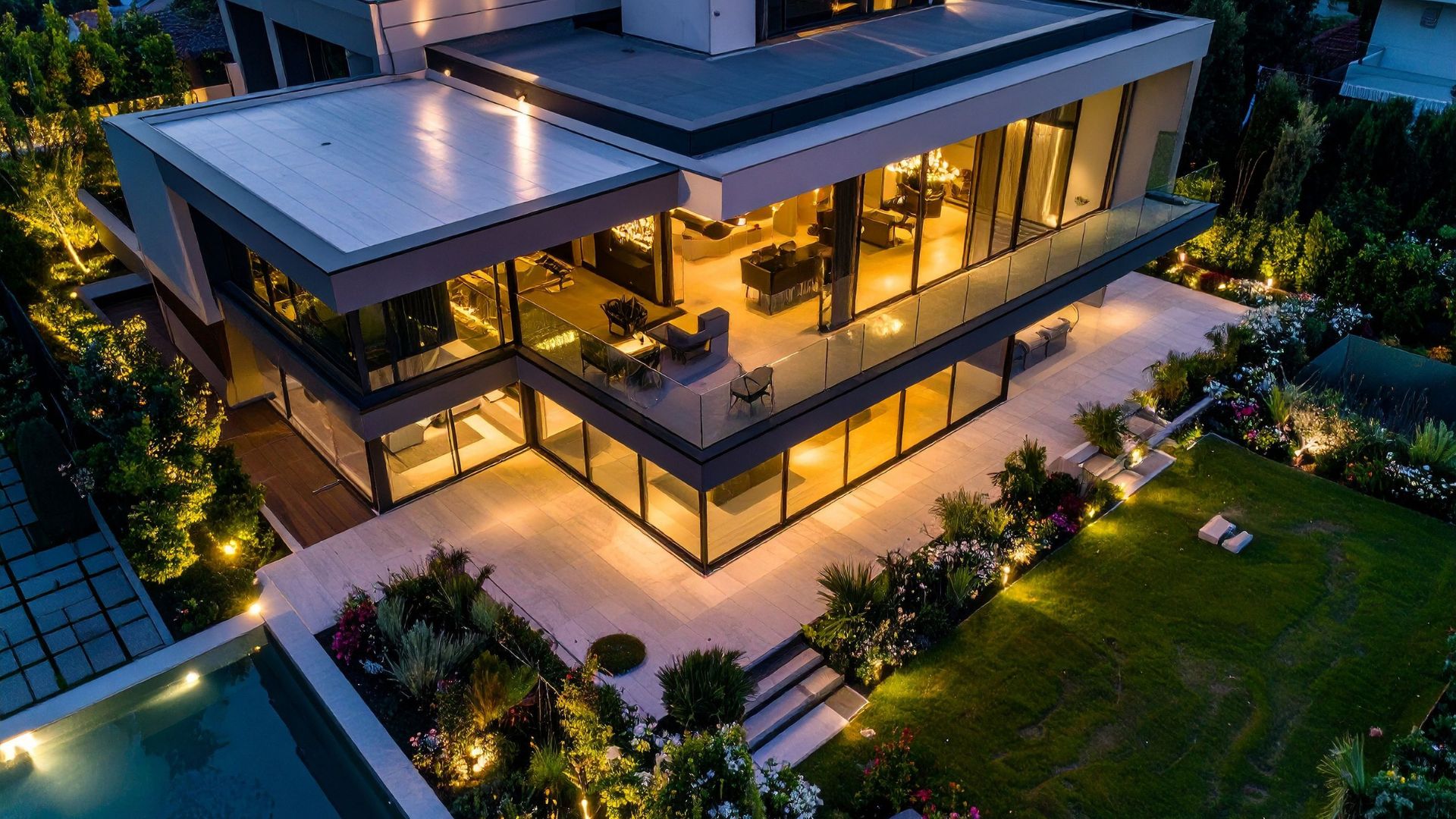 Aerial twilight photo of a modern Emerald Coast home with warm interior lighting